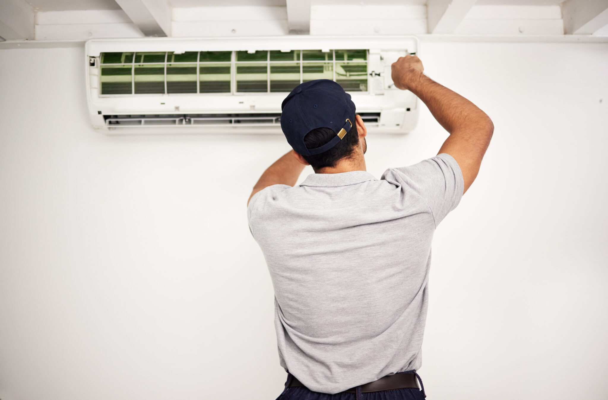 Pelican Heating and Air technician servicing a residential air conditioning unit in Bellevue, WA