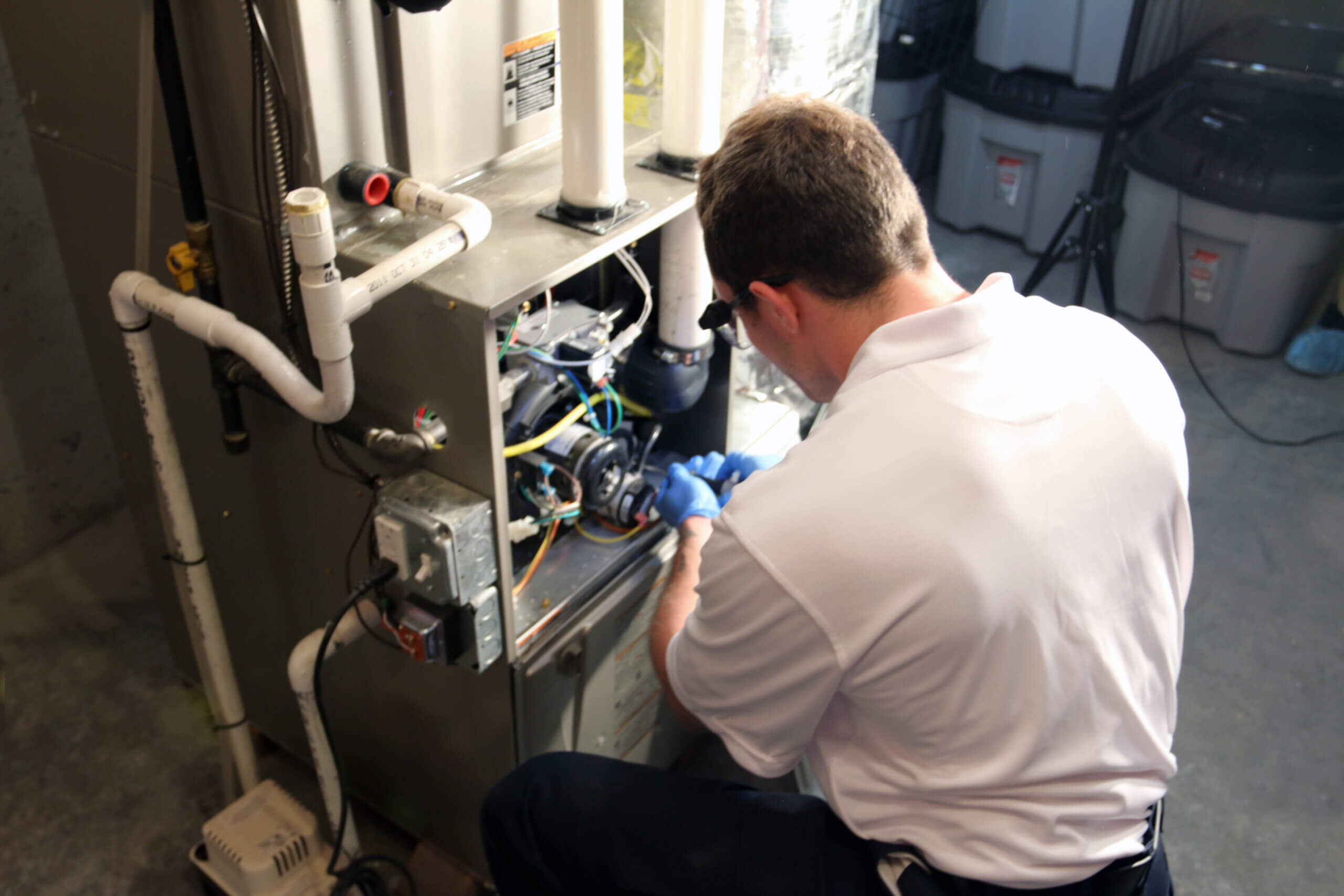 Pelican Heating and Air technician servicing a residential air conditioning unit in Bellevue, WA