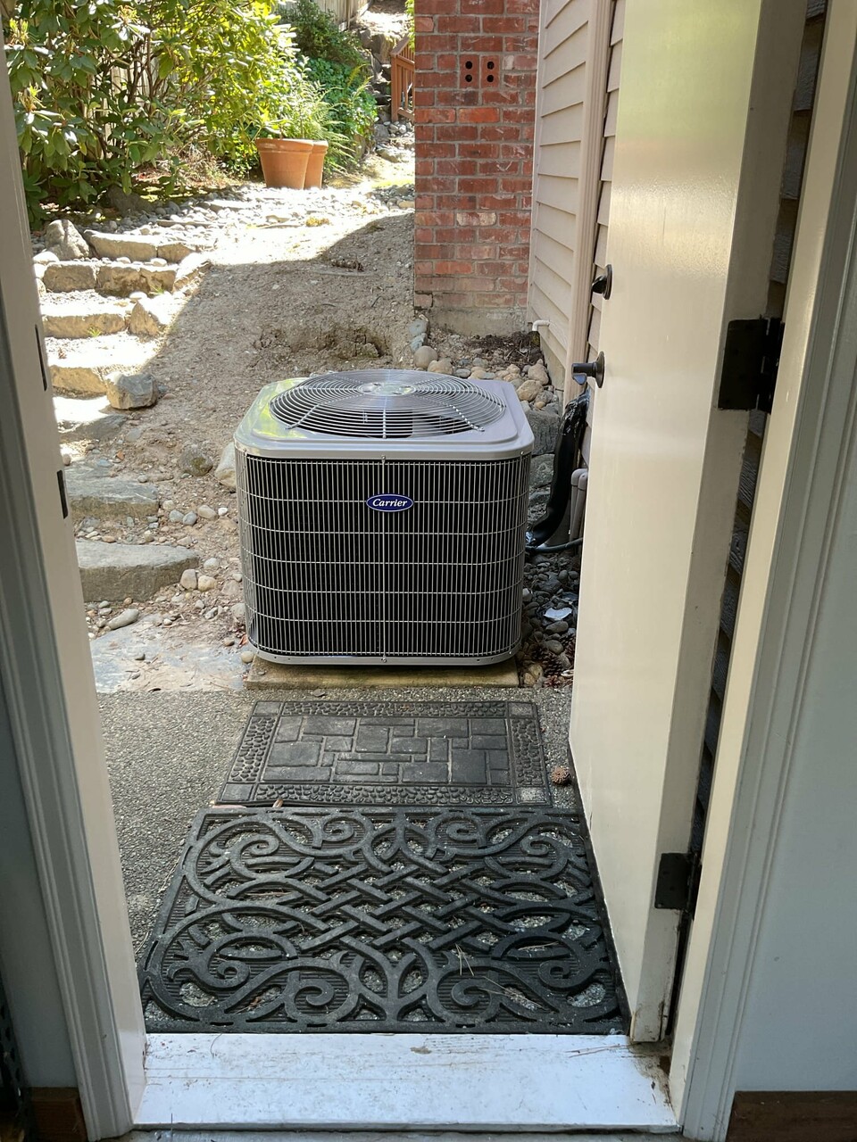 Pelican Heating and Air technician servicing a residential air conditioning unit in Bellevue, WA