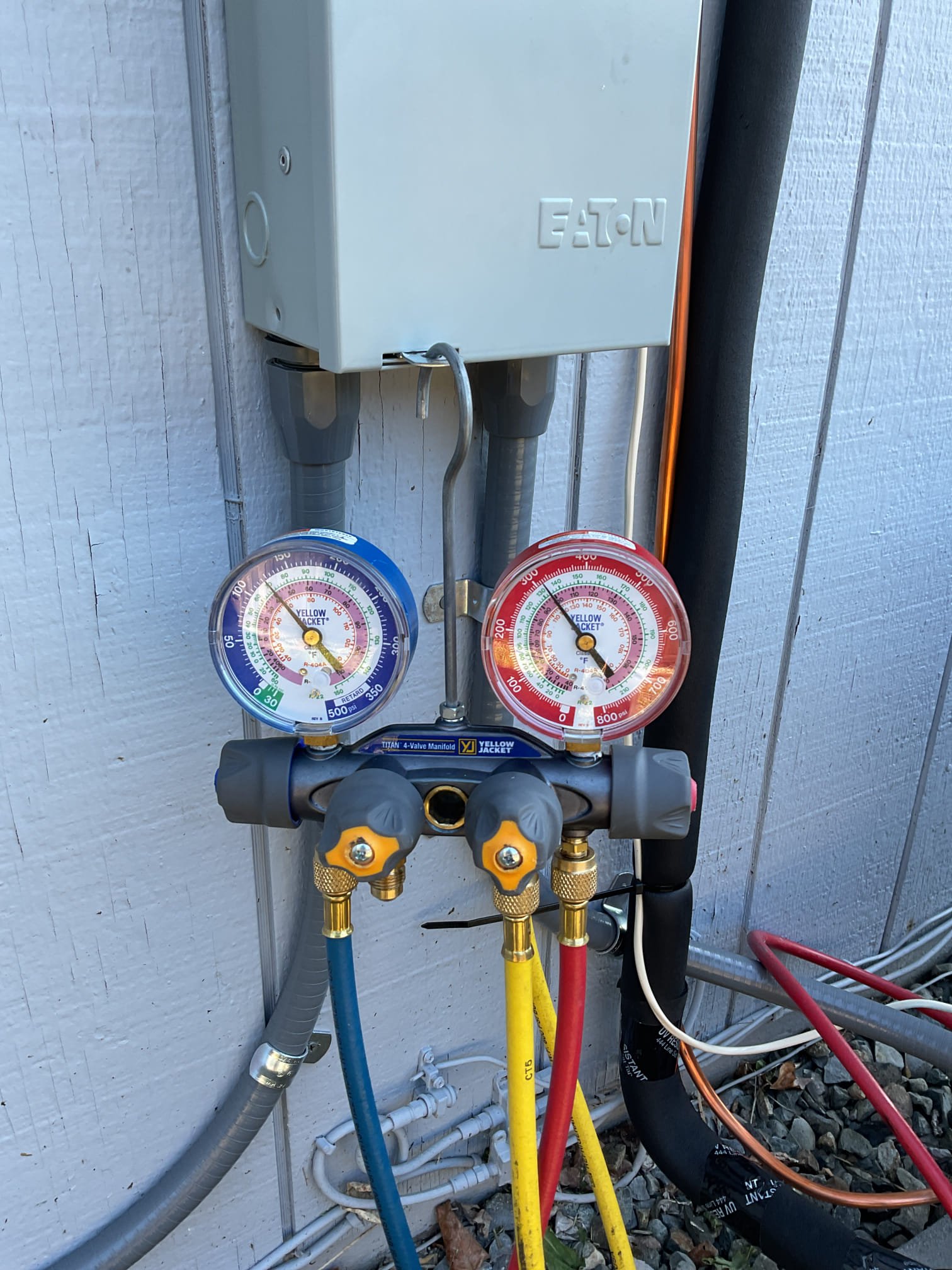 Boiler Service in Seattle, WA technician checking gauges beside a residential heating unit