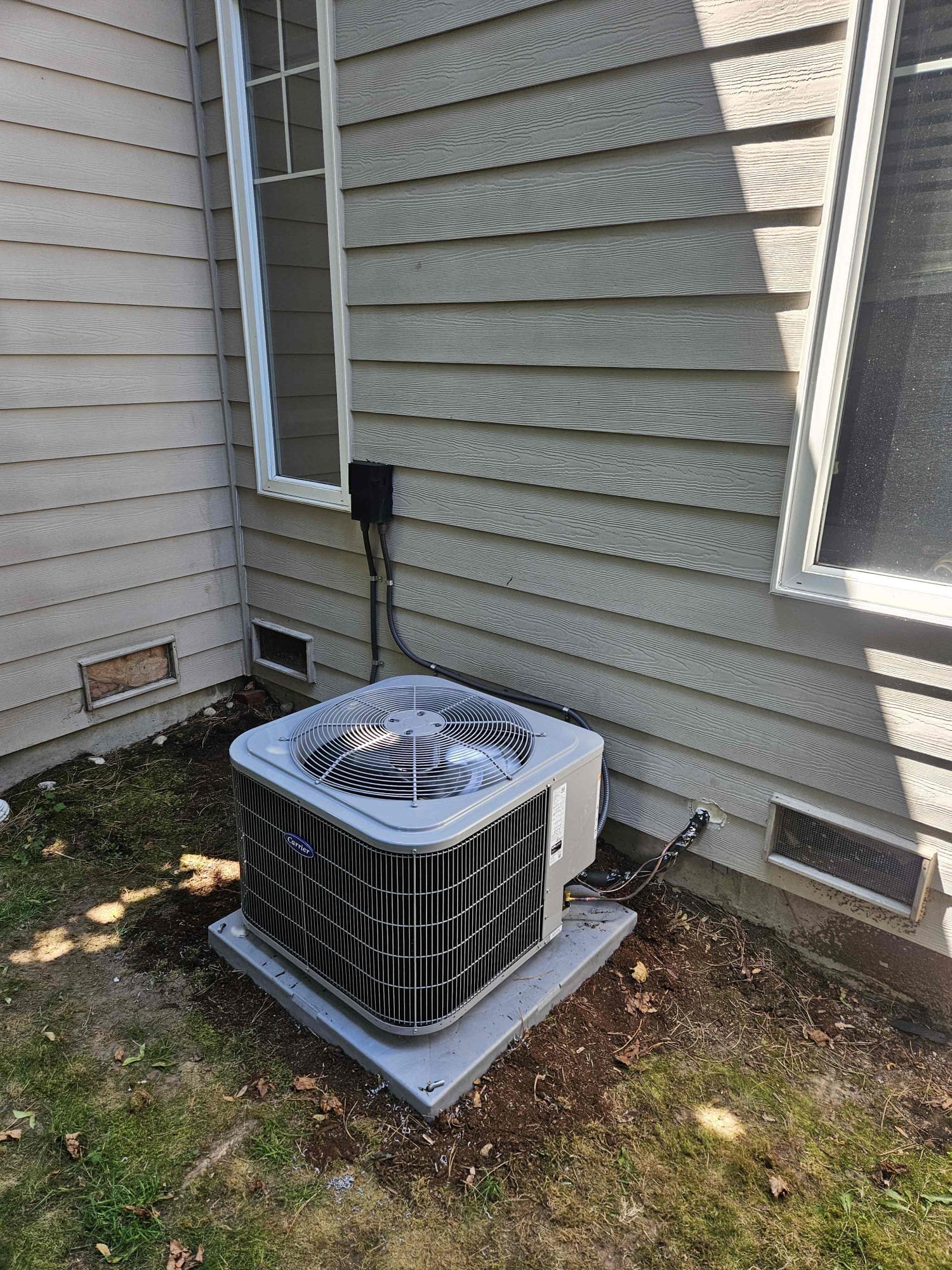 Pelican Heating and Air technician servicing a residential air conditioning unit in Bellevue, WA