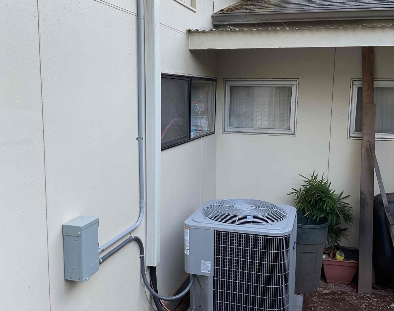 Technician installing Daikin heat pump outside a Seattle home during a rainy afternoon
