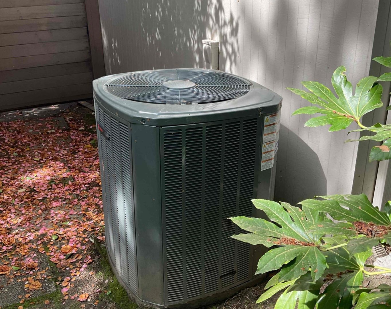 Pelican Heating and Air technician servicing a residential air conditioning unit in Bellevue, WA