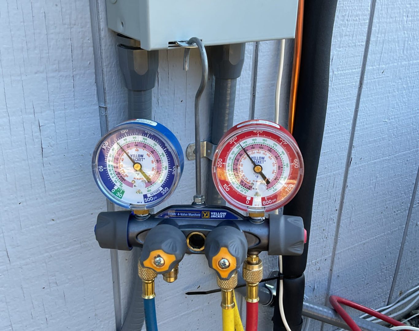 Boiler Service in Seattle, WA technician checking gauges beside a residential heating unit