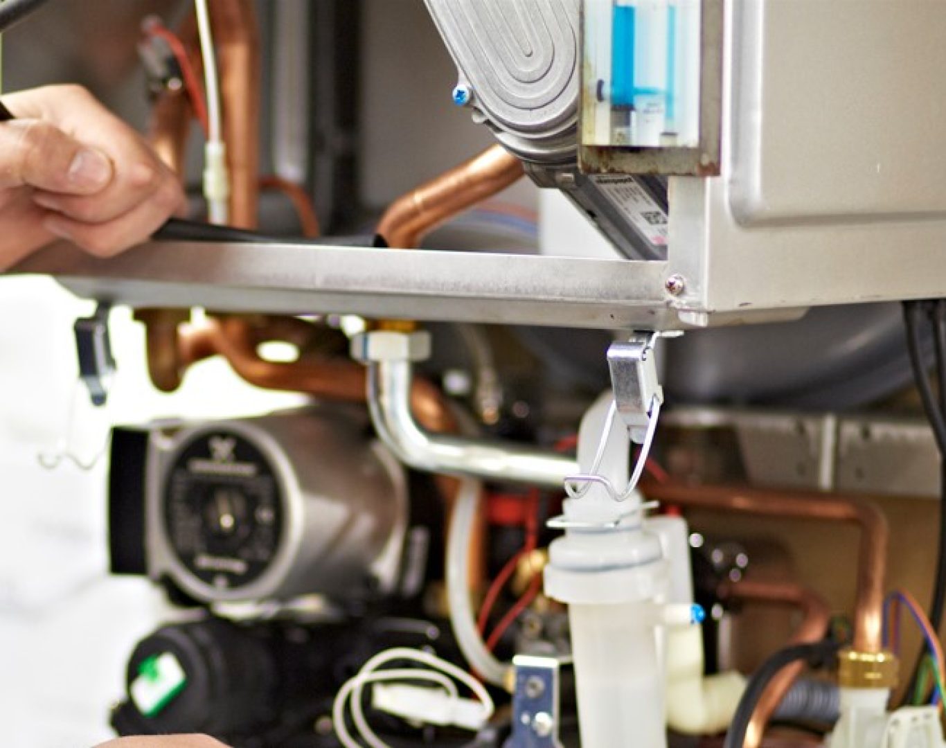 Technician from Pelican Heating & Air inspecting a residential boiler in a Bellevue, WA home basement