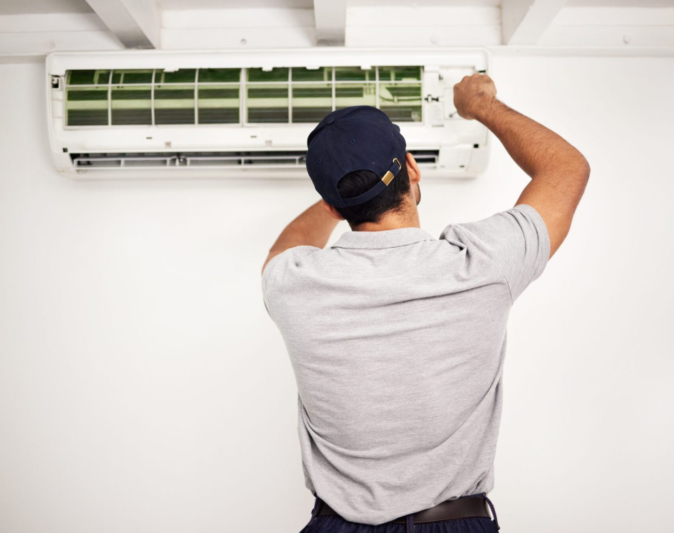 Pelican Heating and Air technician servicing a residential air conditioning unit in Bellevue, WA