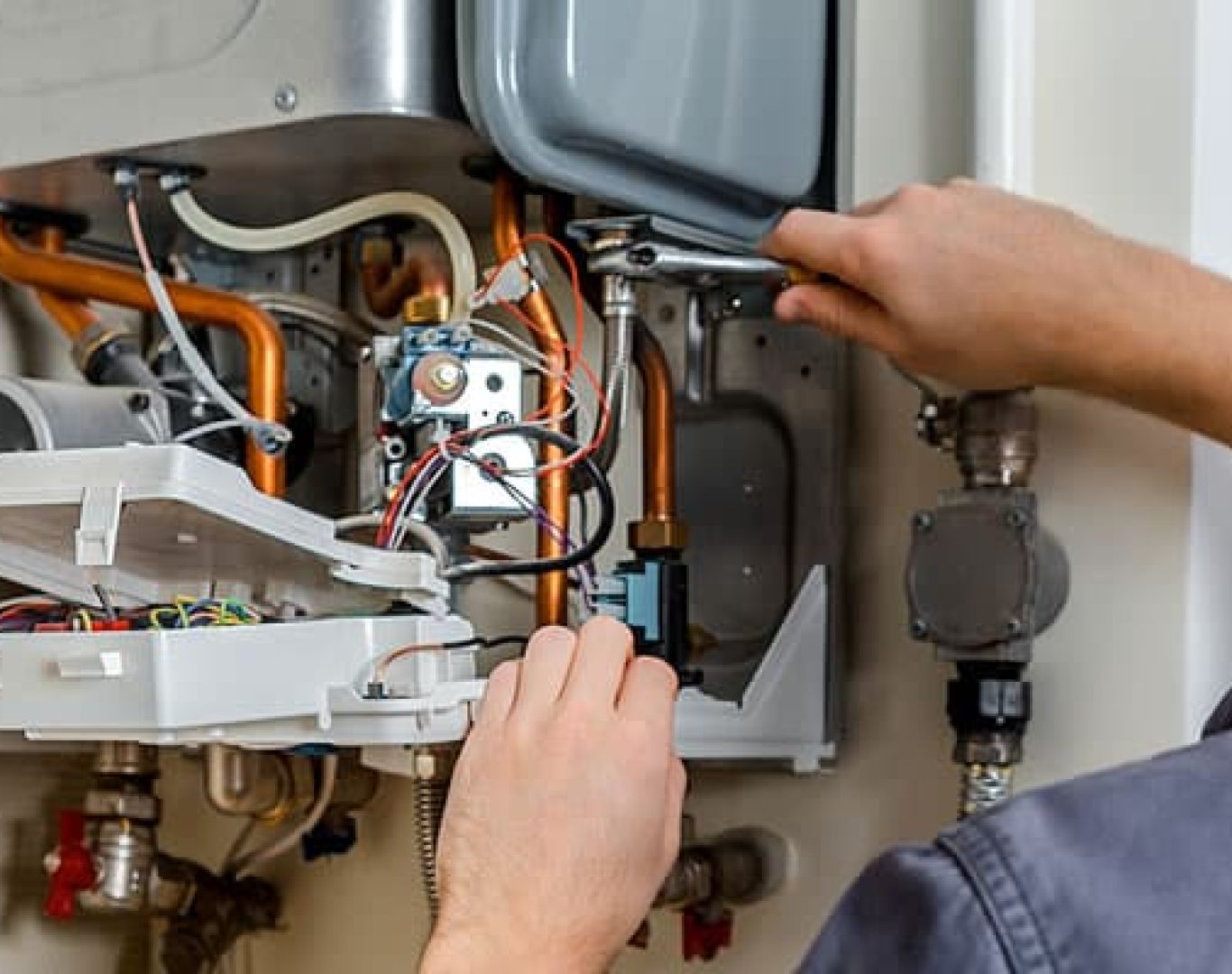 Technician reviewing maintenance checklist while servicing a complex boiler system in a Bellevue, WA apartment building