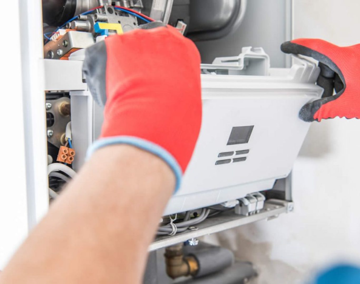 Experienced technician calibrating boiler controls using diagnostic tools in a Bellevue, WA utility room