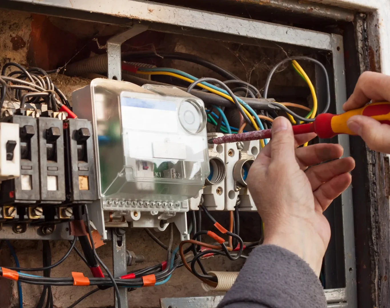Technician from Pelican Heating & Air servicing air conditioner in Newcastle backyard