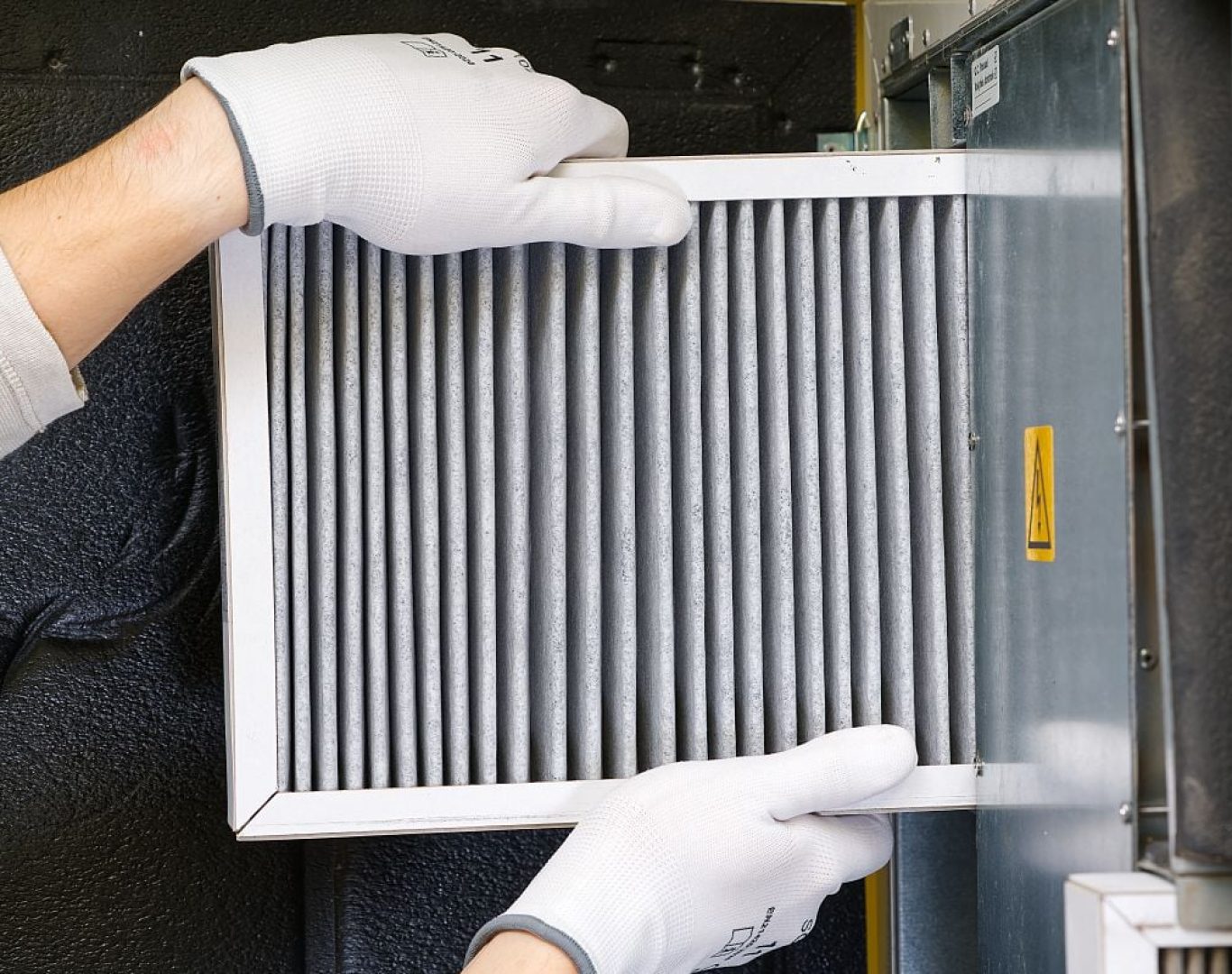 Pelican Heating & Air technician expertly cleaning a furnace in Mercer Island, ensuring optimal efficiency and safety