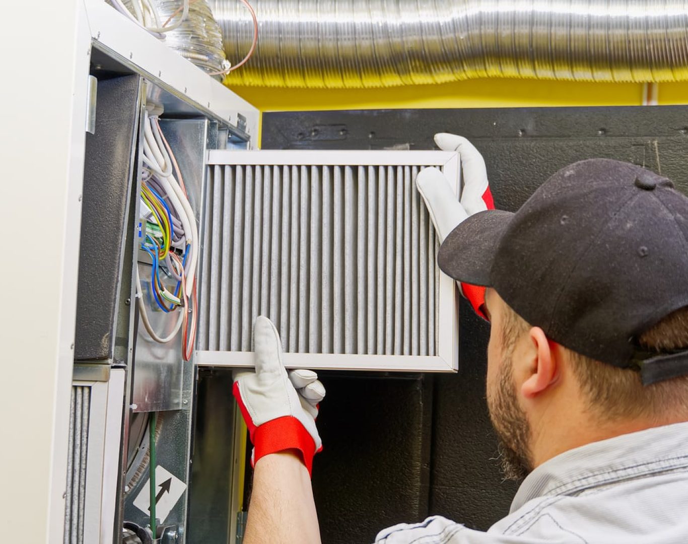 Pelican Heating & Air technician employing advanced cleaning techniques for a furnace in a Kirkland home